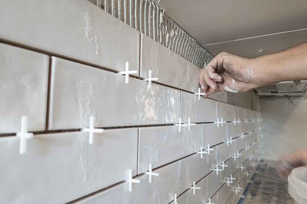 Kitchen tiling contractor installing backsplash in kitchen