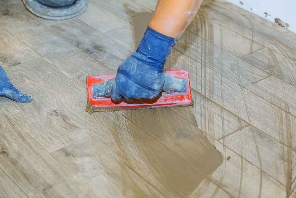 Man grouting newly installed outdoor tile